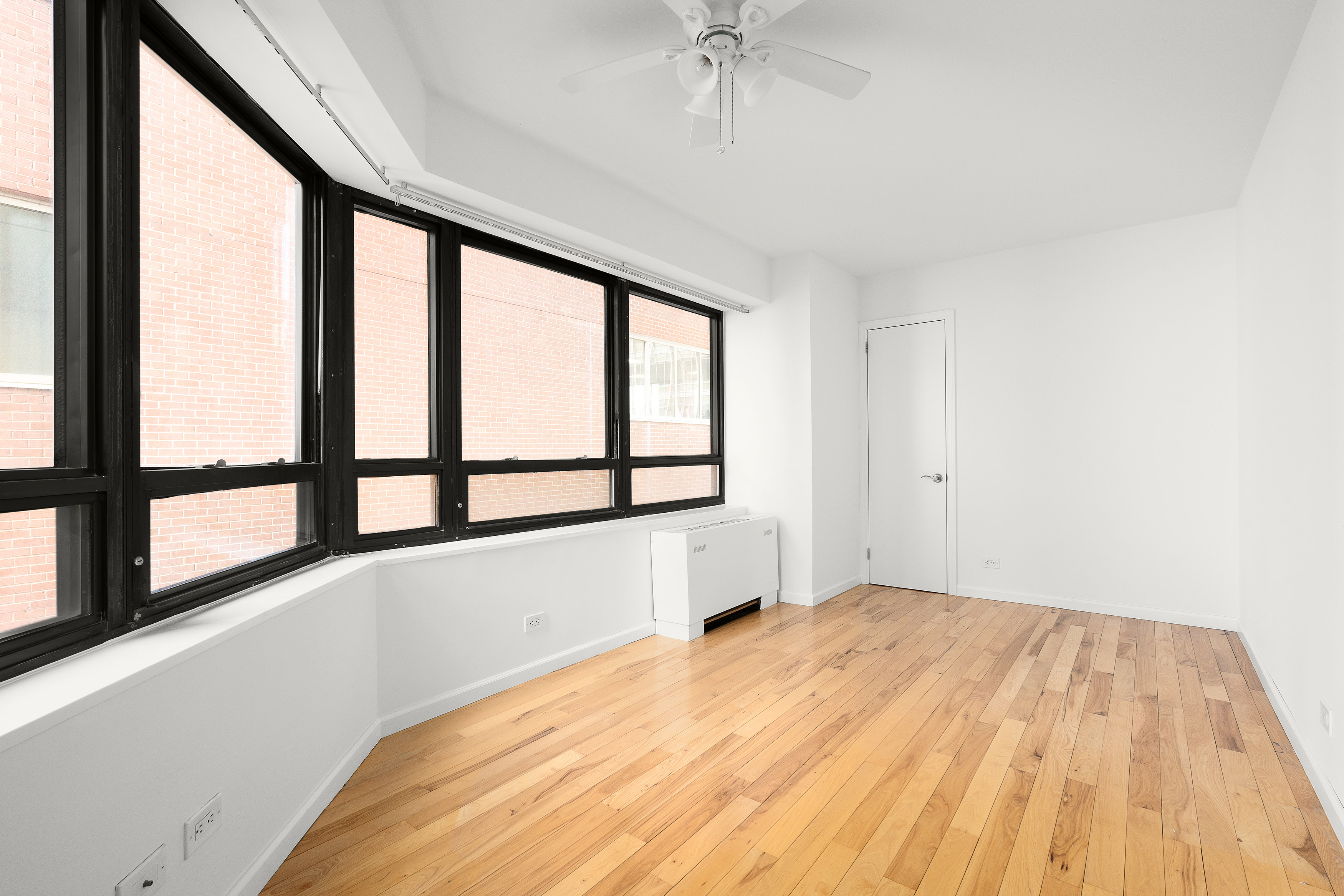 240 East 47th Street, Unit 4B Manhattan, NY 10017 - Photo 10 of 25 a view of empty room with wooden floor and fan