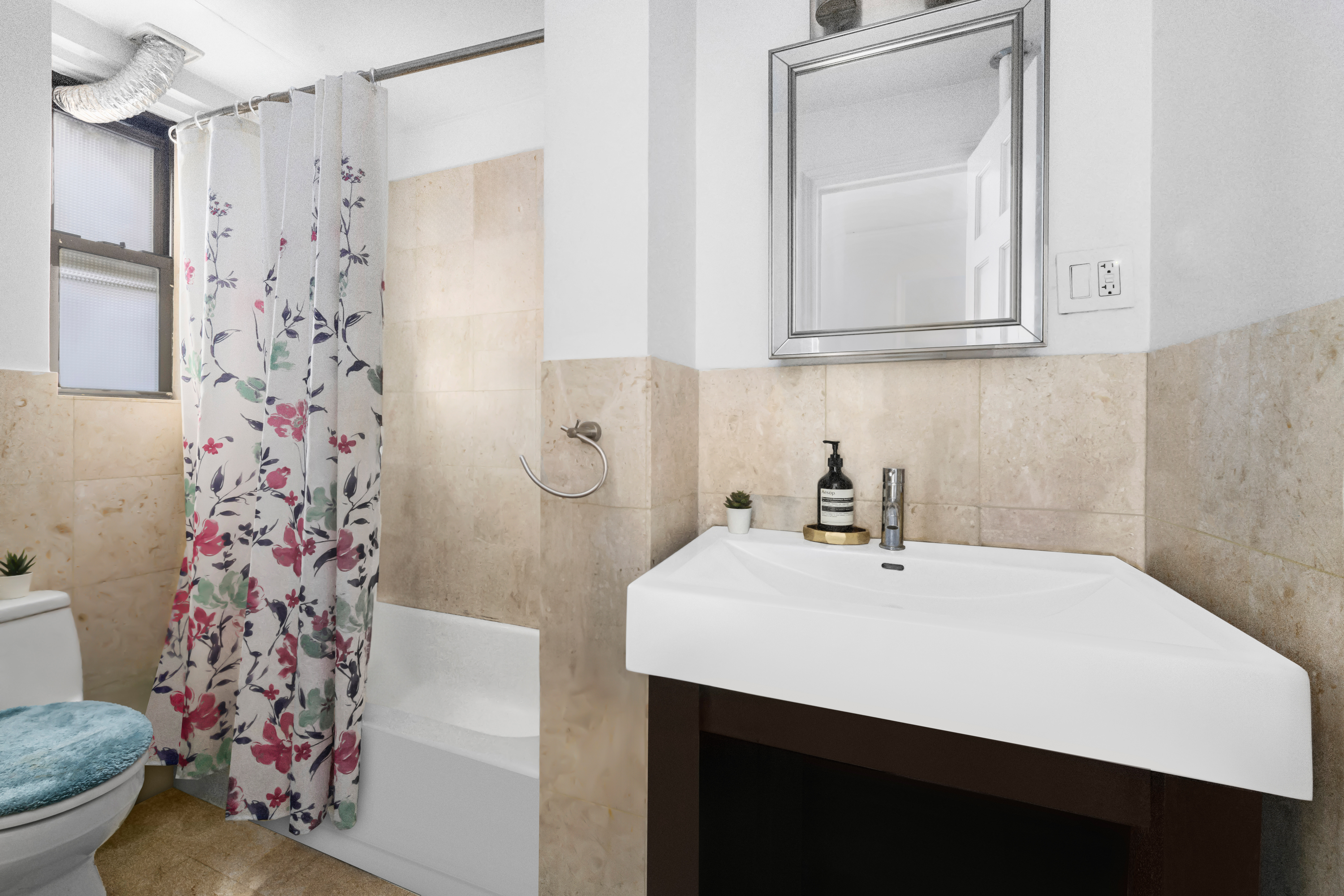 142 East 49th Street, Unit 7B Manhattan, NY 10017 - Photo 4 of 11 a bathroom with a sink a toilet and shower curtain