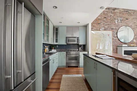 a kitchen with stainless steel appliances granite countertop a sink and a stove