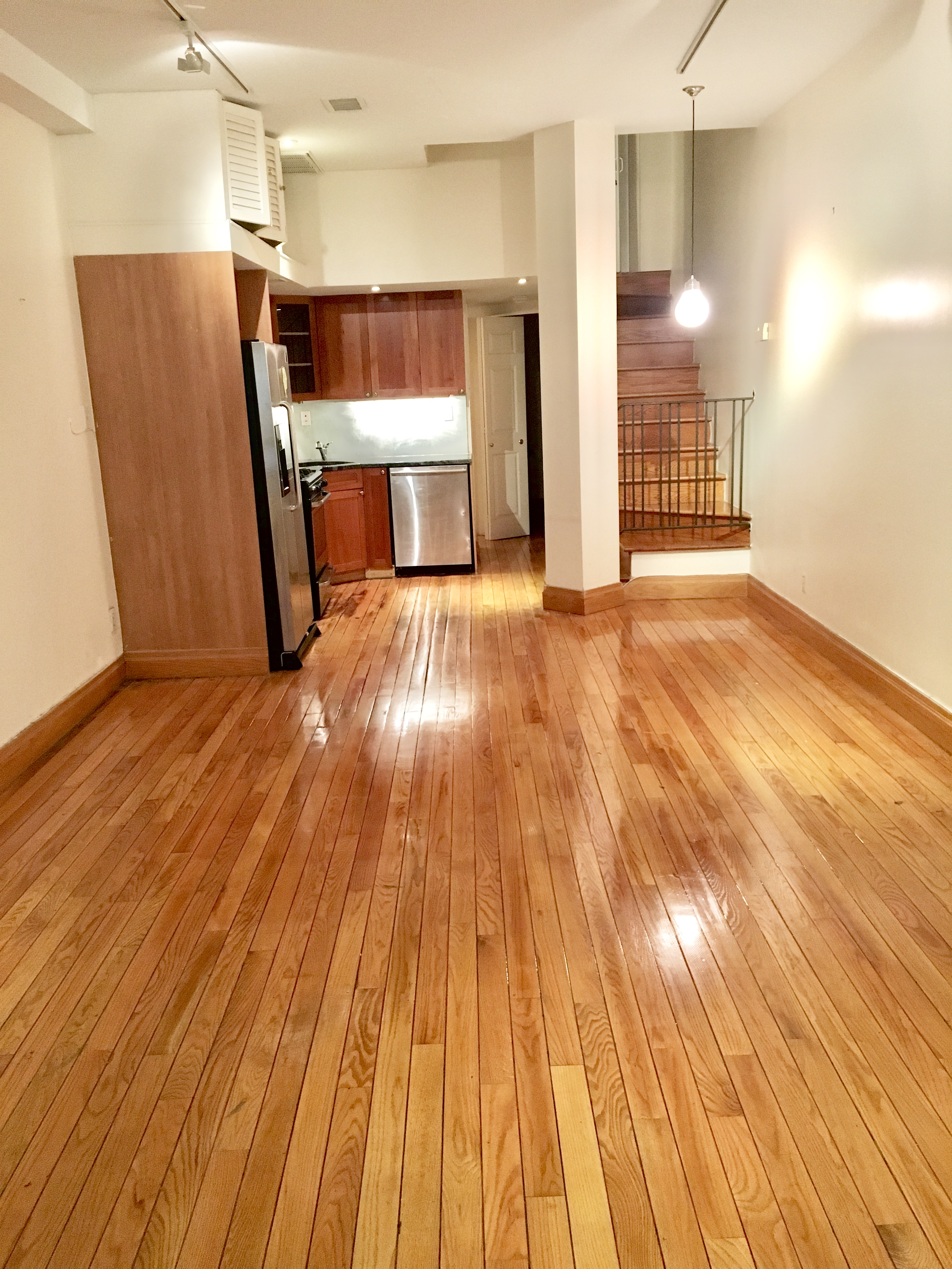 162 Christopher Street, Unit TH4 Manhattan, NY 10014 - Photo 2 of 5 a view of empty room with wooden floor and kitchen