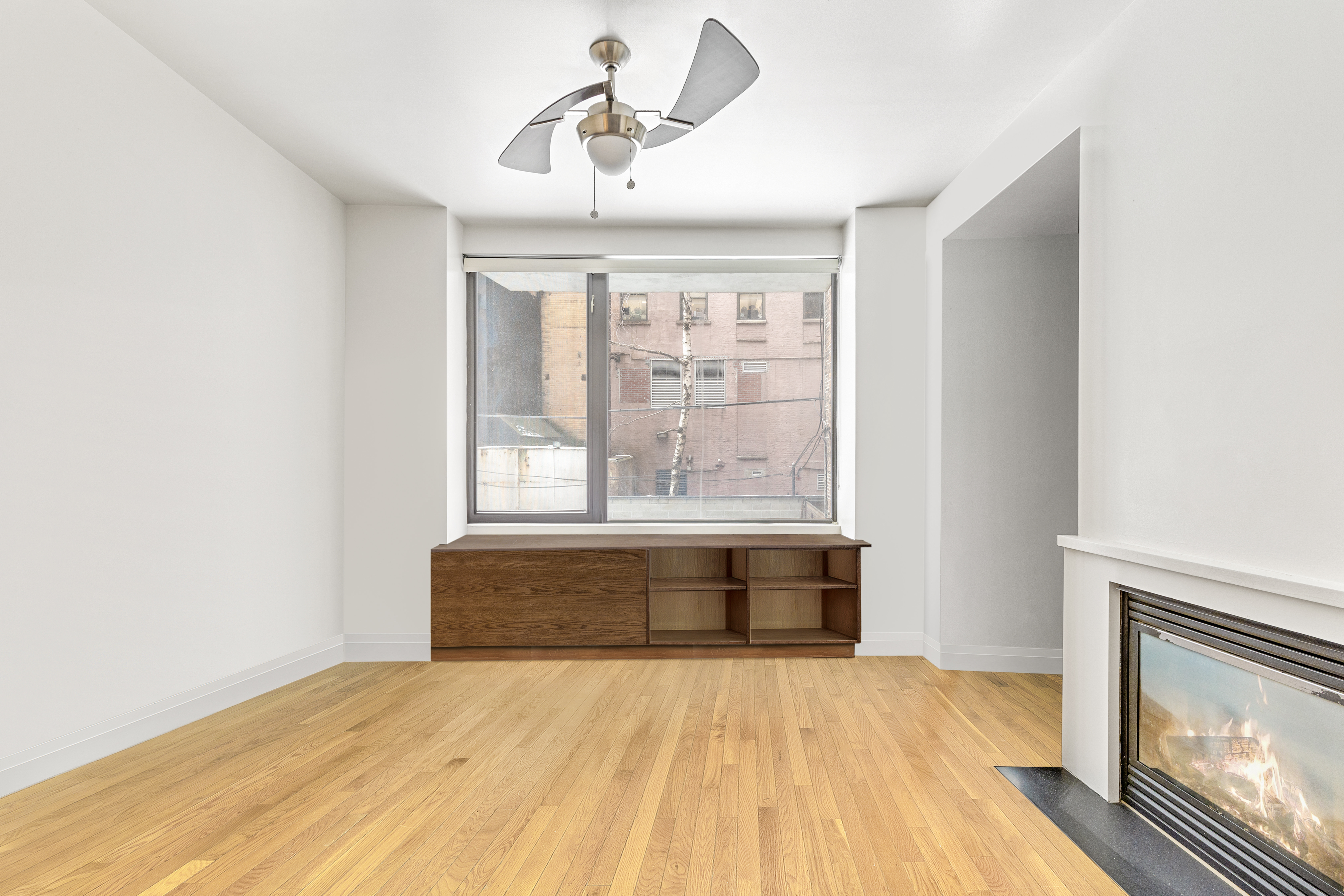 212 East 95th Street, Unit 2C Manhattan, NY 10128 - Photo 2 of 11 a view of room with wooden floor and fan