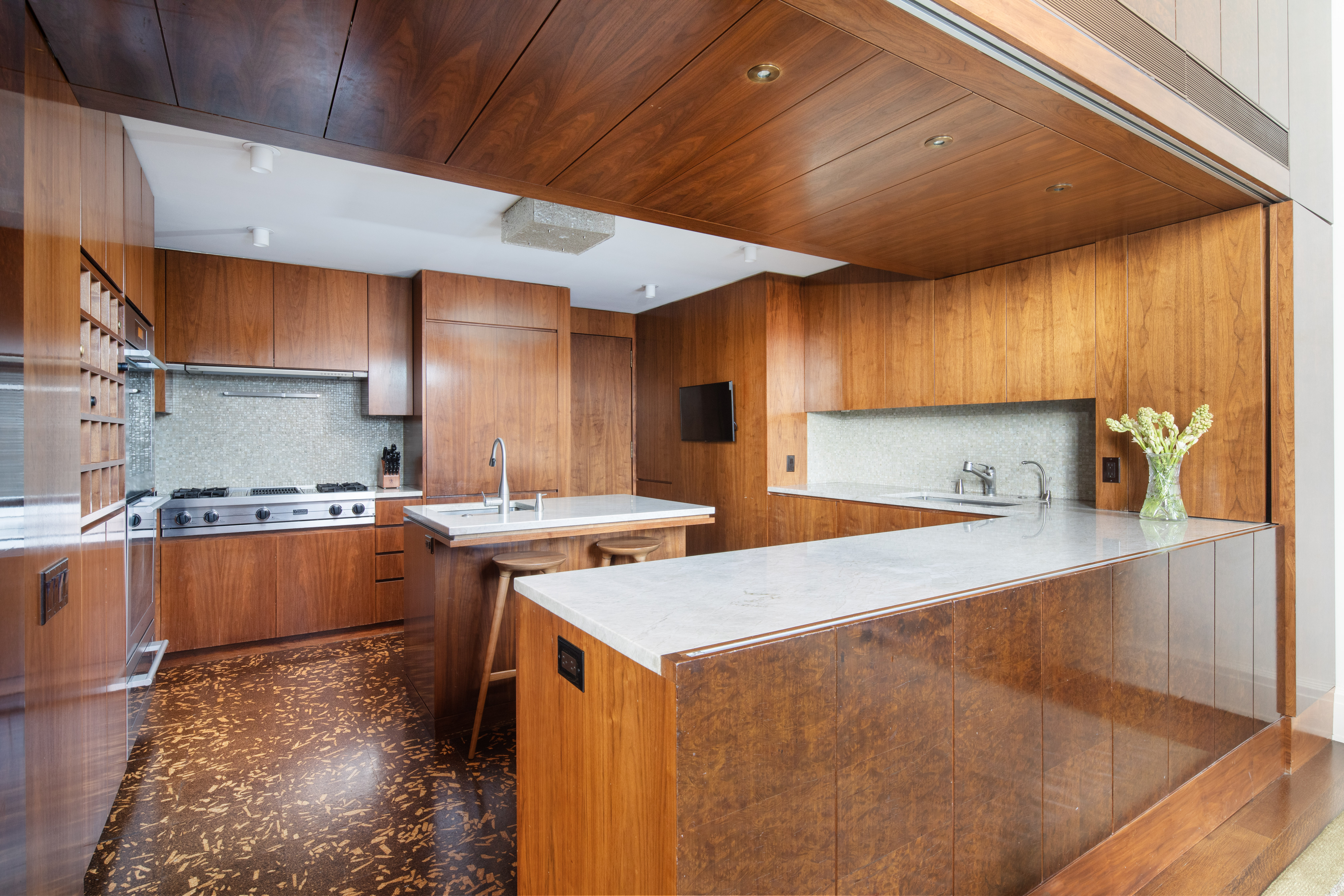 1 West 67th Street, Unit 606607 Manhattan, NY 10023 - Photo 9 of 15 a kitchen with wooden cabinets and a sink