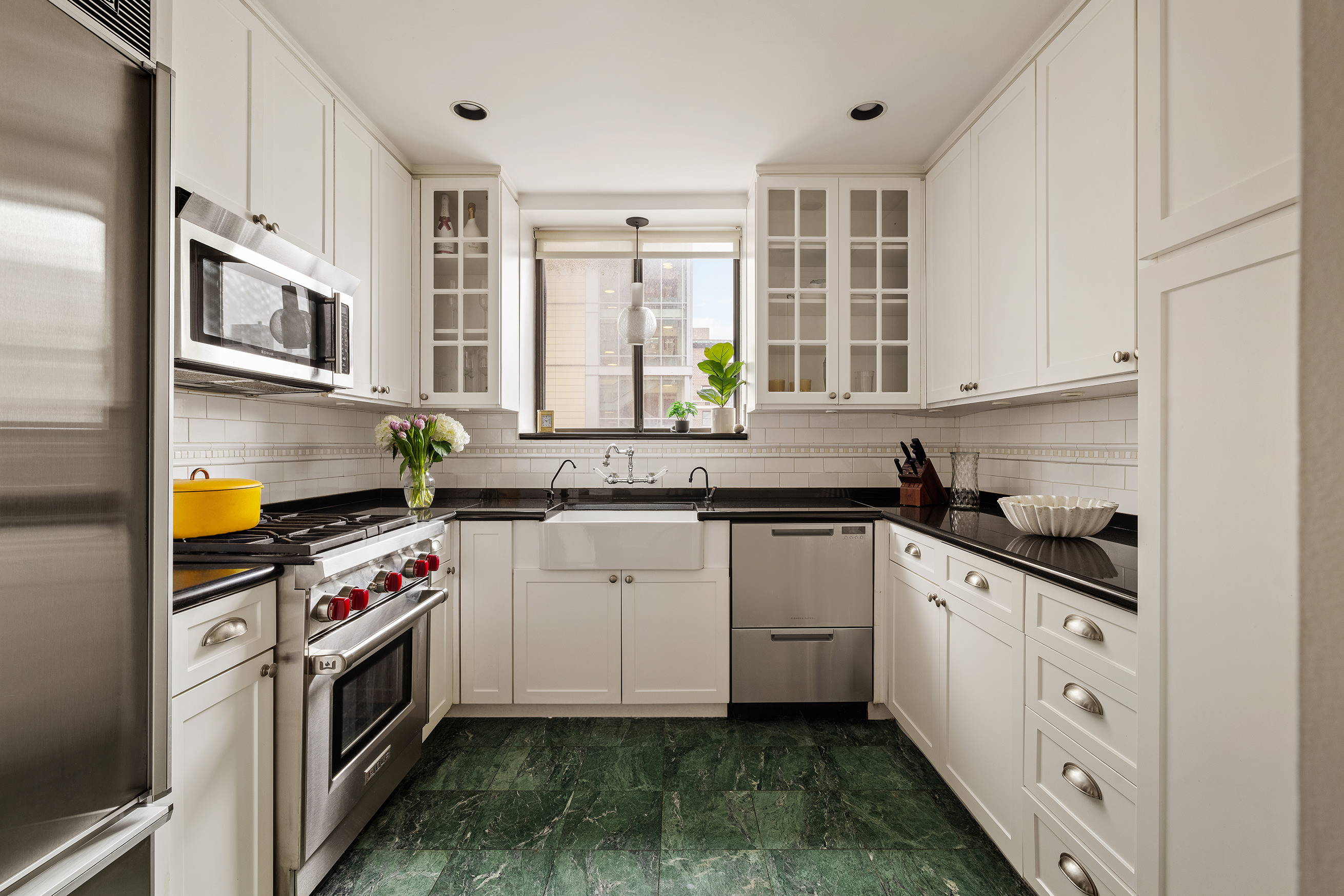 131 East 81st Street, Unit 9 Manhattan, NY 10028 - Photo 3 of 10 a kitchen with stainless steel appliances granite countertop a sink stove and cabinets