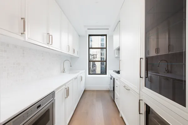 a kitchen with white cabinets and white appliances