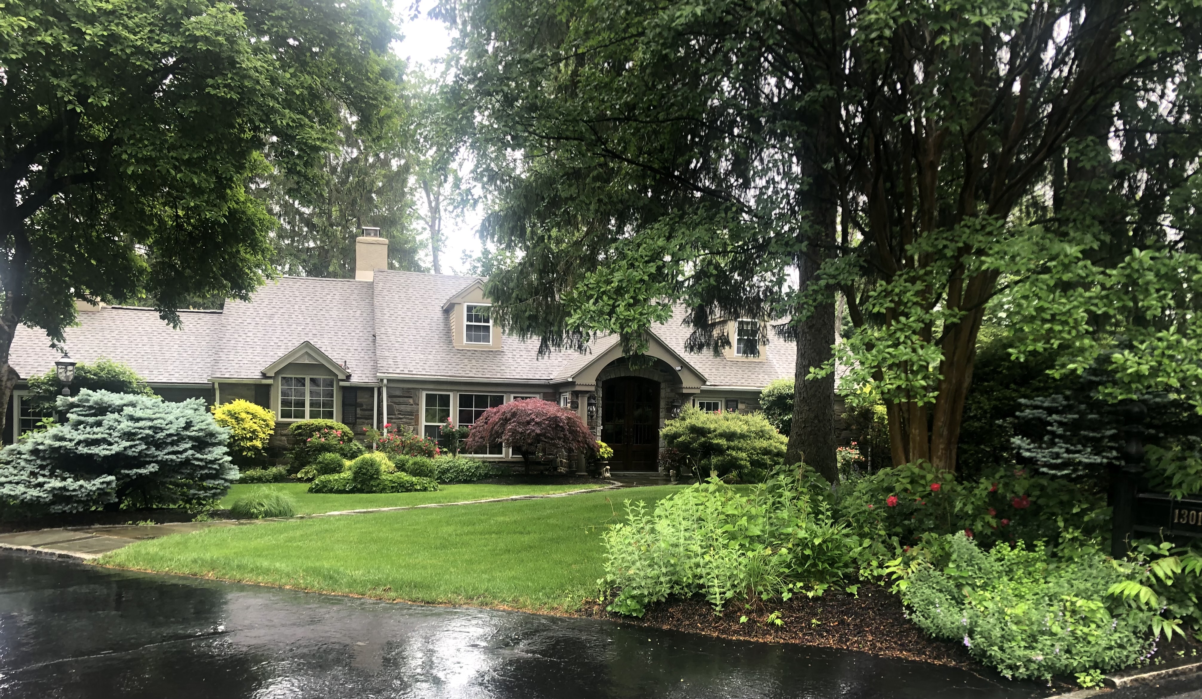 a front view of a house with a yard and potted plants