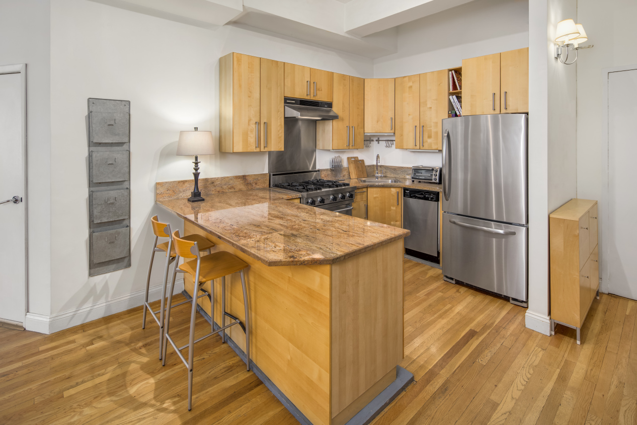 425 Park Avenue South, Unit 9B Manhattan, NY 10016 - Photo 3 of 7 a kitchen with stainless steel appliances granite countertop a refrigerator a stove and a sink with wooden floor