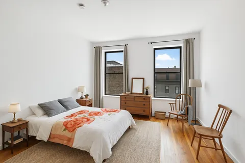 a bedroom with a bed and a large window