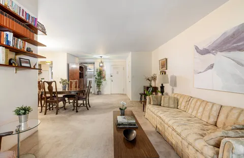a living room with furniture and a dining table with chairs