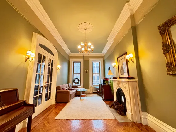 a living room with furniture a fireplace and a chandelier