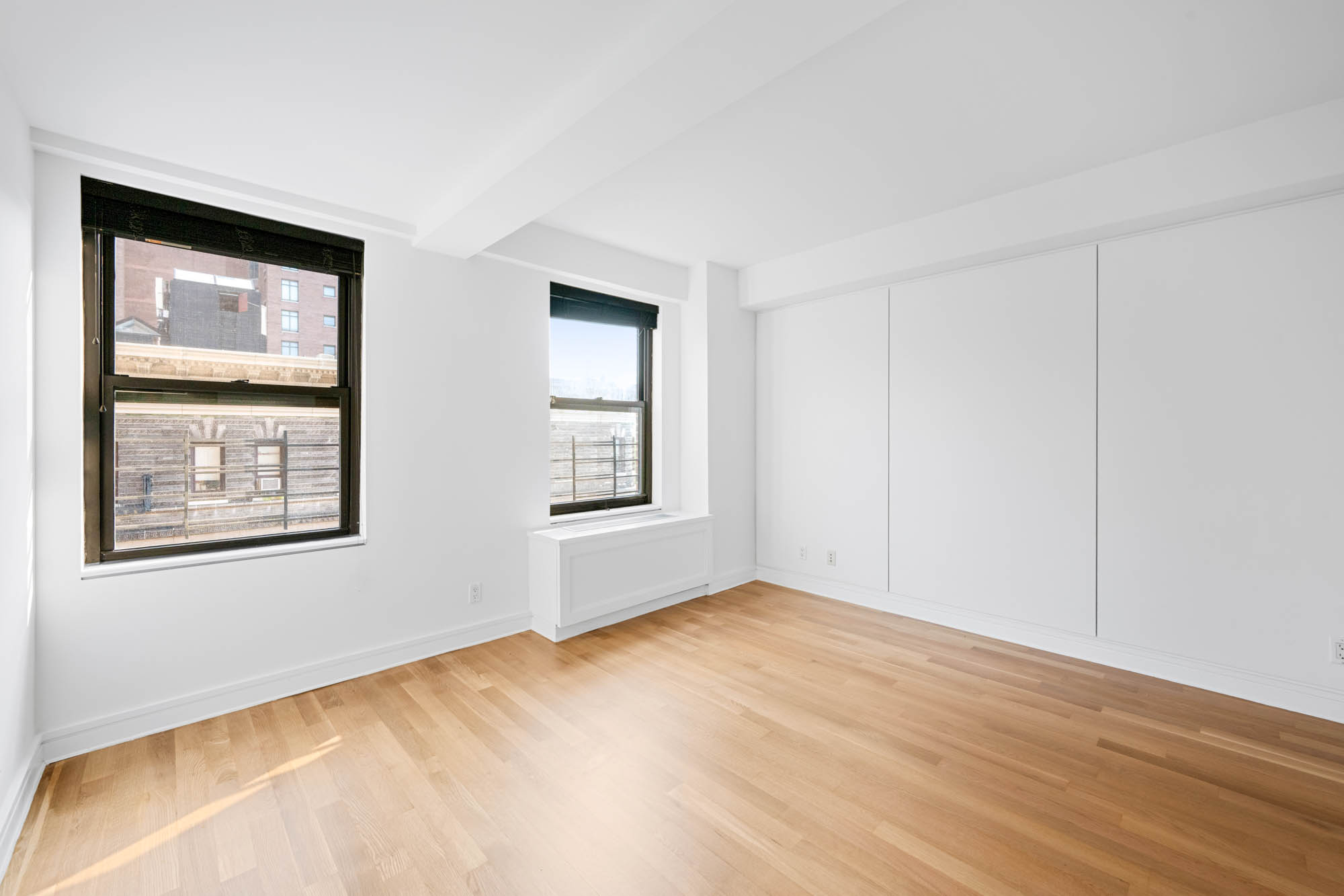 230 Riverside Drive, Unit 8D Manhattan, NY 10025 - Photo 12 of 19 a view of an empty room with window and wooden floor