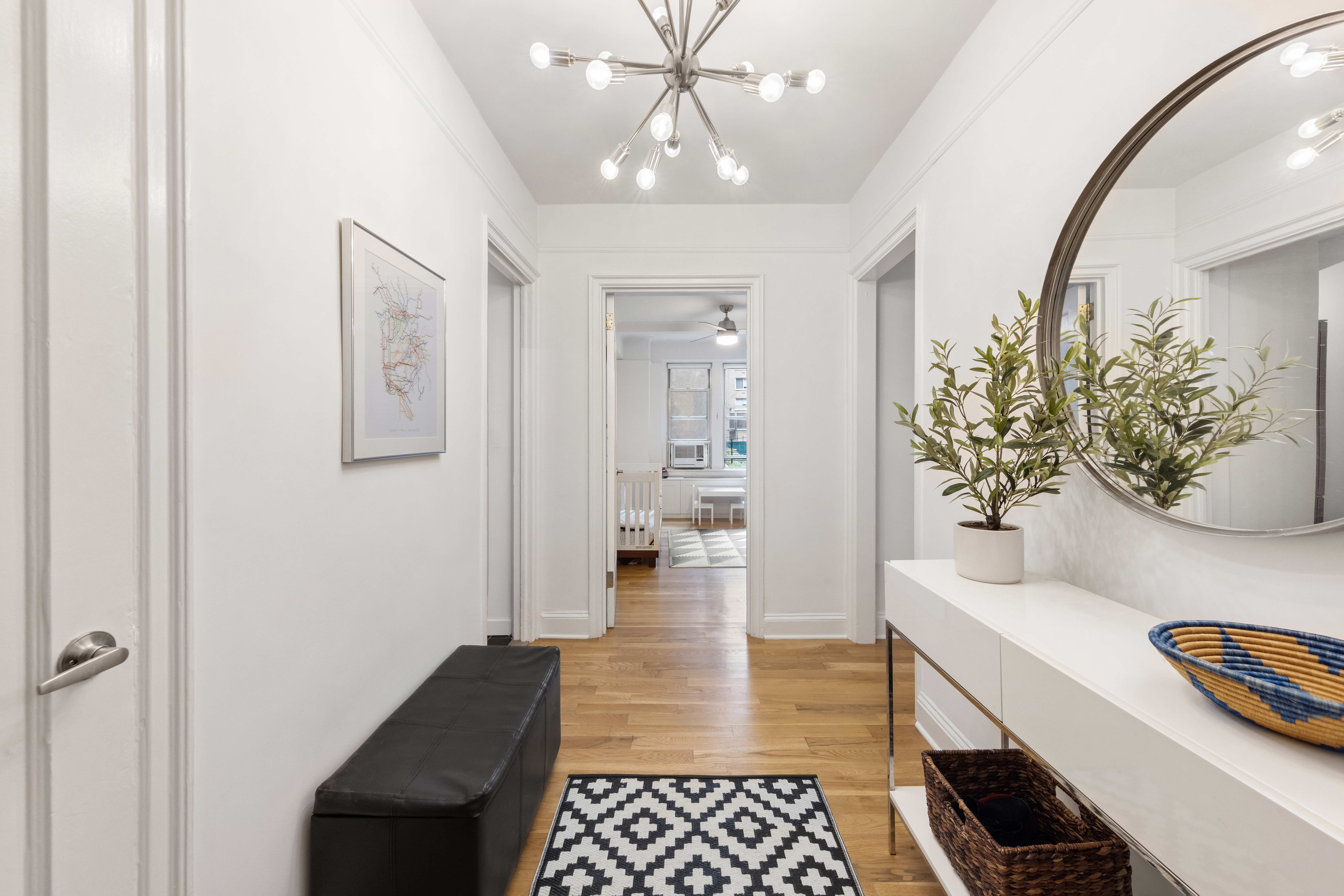 425 East 86th Street, Unit 2F Manhattan, NY 10028 - Photo 3 of 11 a hallway with wooden floor and a chandelier