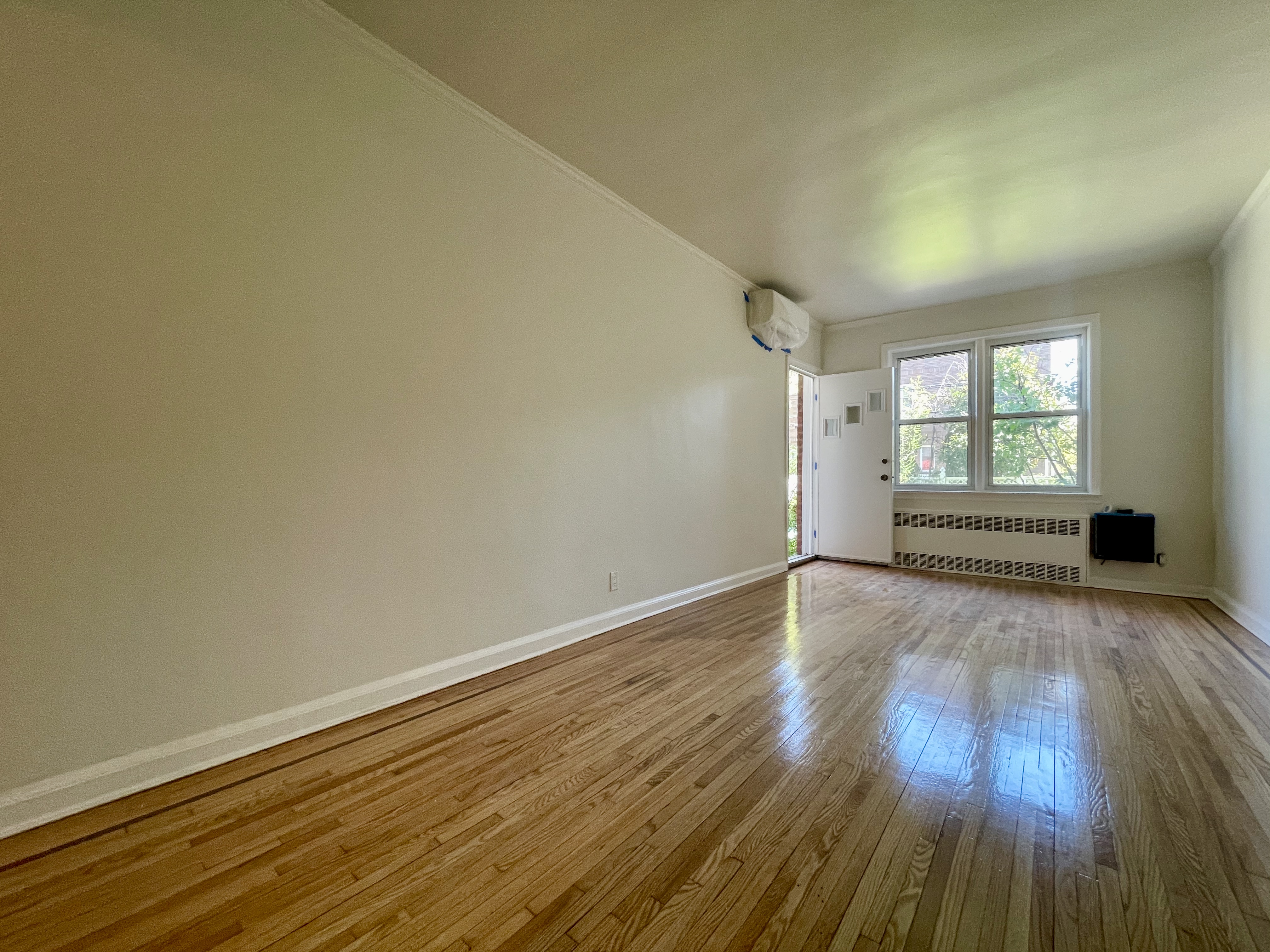144 96th Street Brooklyn, NY 11209 - Photo 8 of 9 an empty room with wooden floor and windows
