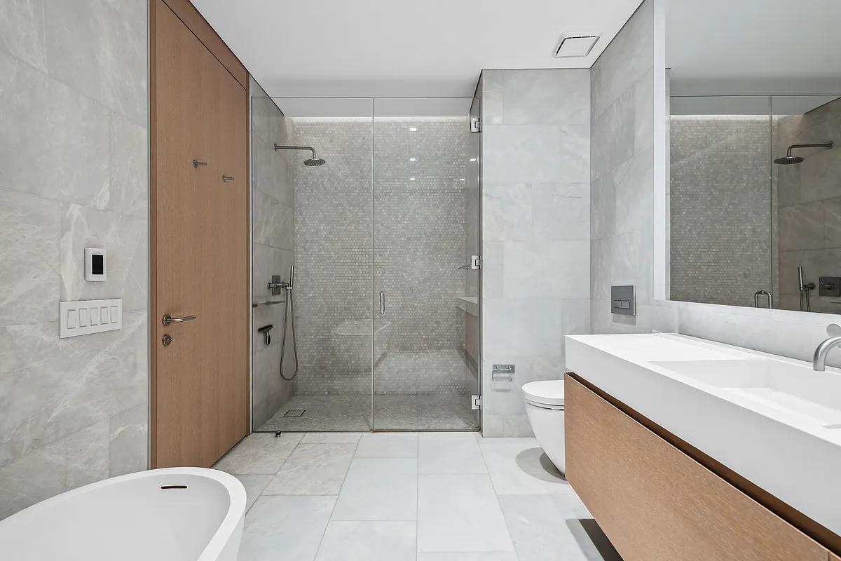 49 Chambers Street, Unit 14C Manhattan, NY 10007 - Photo 6 of 26 a bathroom with a bathtub shower sink mirror and toilet