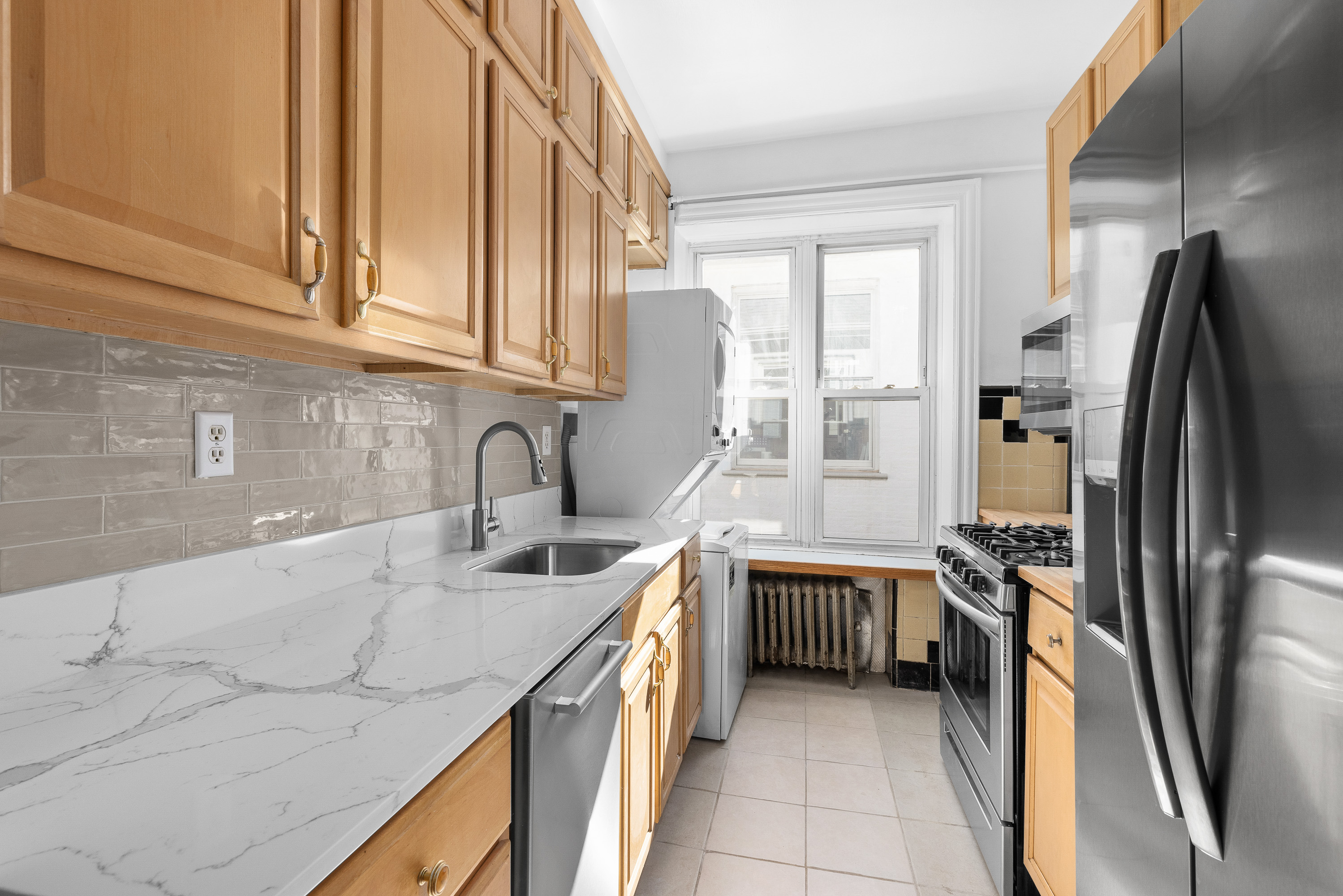 124 Terrace Place, Unit 2 Brooklyn, NY 11218 - Photo 2 of 8 a kitchen with stainless steel appliances granite countertop a sink and a refrigerator