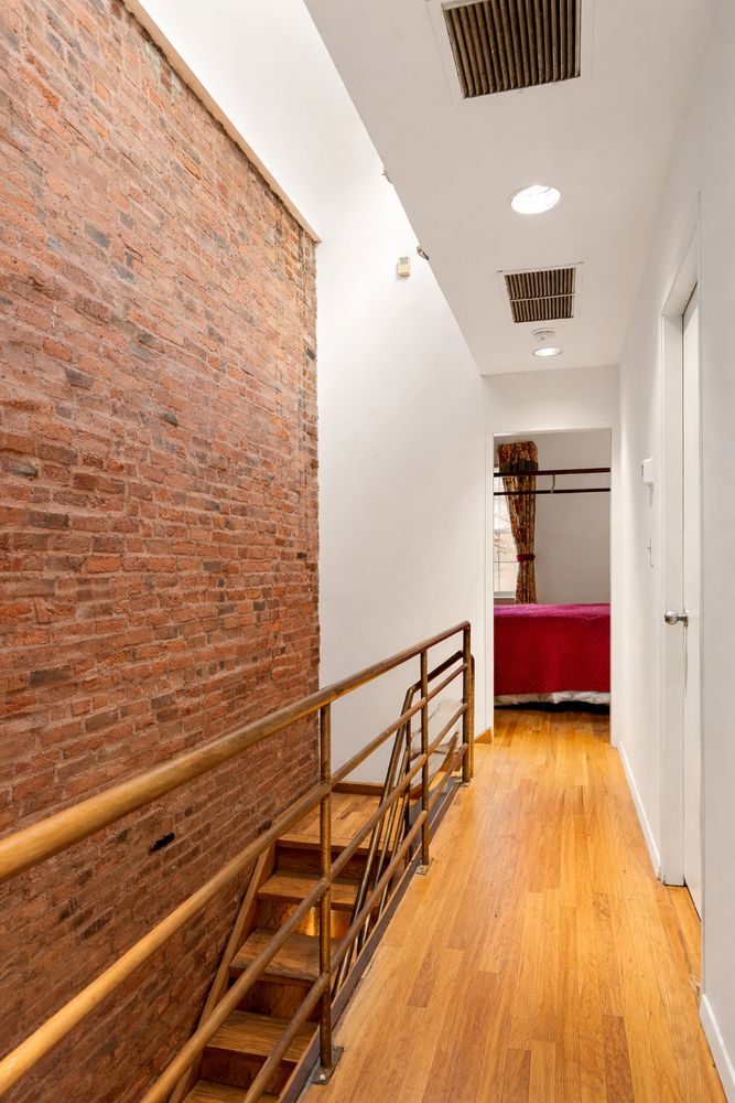 449 1/2 Hudson Street Manhattan, NY 10014 - Photo 9 of 19 a view of hallway with wooden floor and stairs