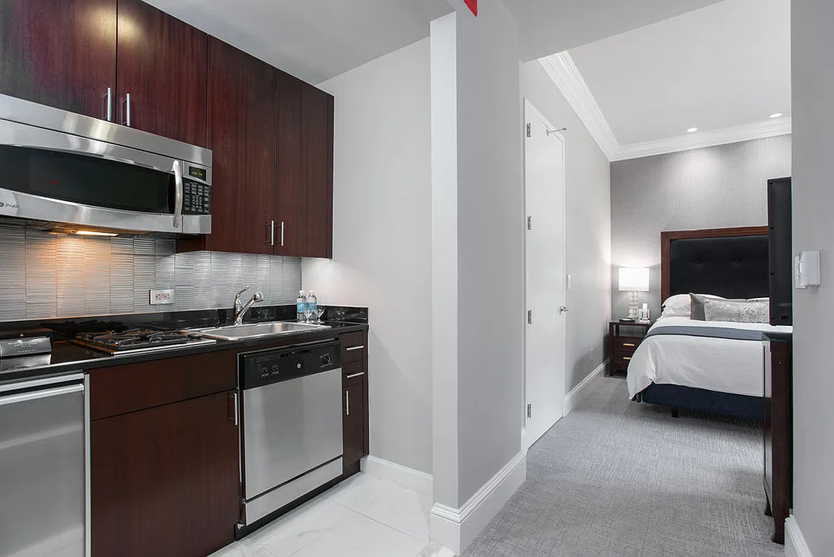 1 Central Park West, Unit 612 Manhattan, NY 10023 - Photo 4 of 13 a kitchen with stainless steel appliances a stove a microwave and cabinets