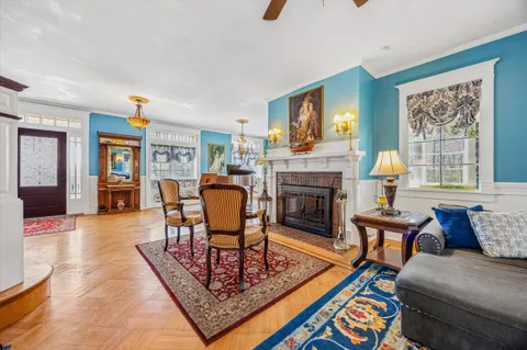 a living room with furniture a fireplace and paintings on the wall