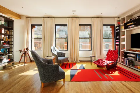 a living room with furniture a flat screen tv and a dining table