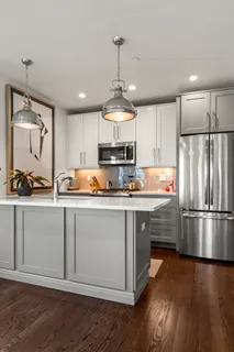 a kitchen with wooden floors and refrigerator