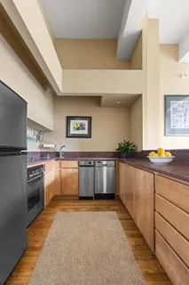 a large kitchen with stainless steel appliances granite countertop a lot of counter top space and wooden floor