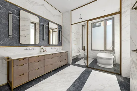 a spacious bathroom with a double vanity sink toilet mirror and windows