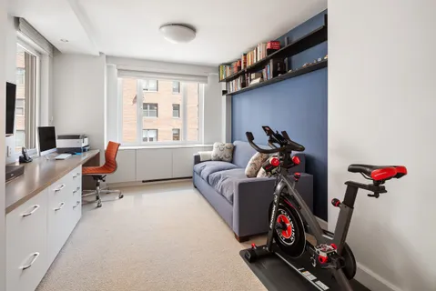 a living room with furniture gym equipment and a flat screen tv