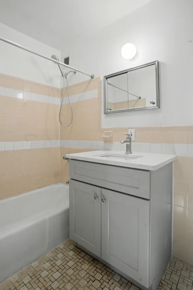 a bathroom with a sink vanity granite tub shower and a mirror