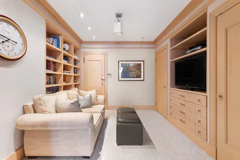 a living room with furniture a flat screen tv and a window