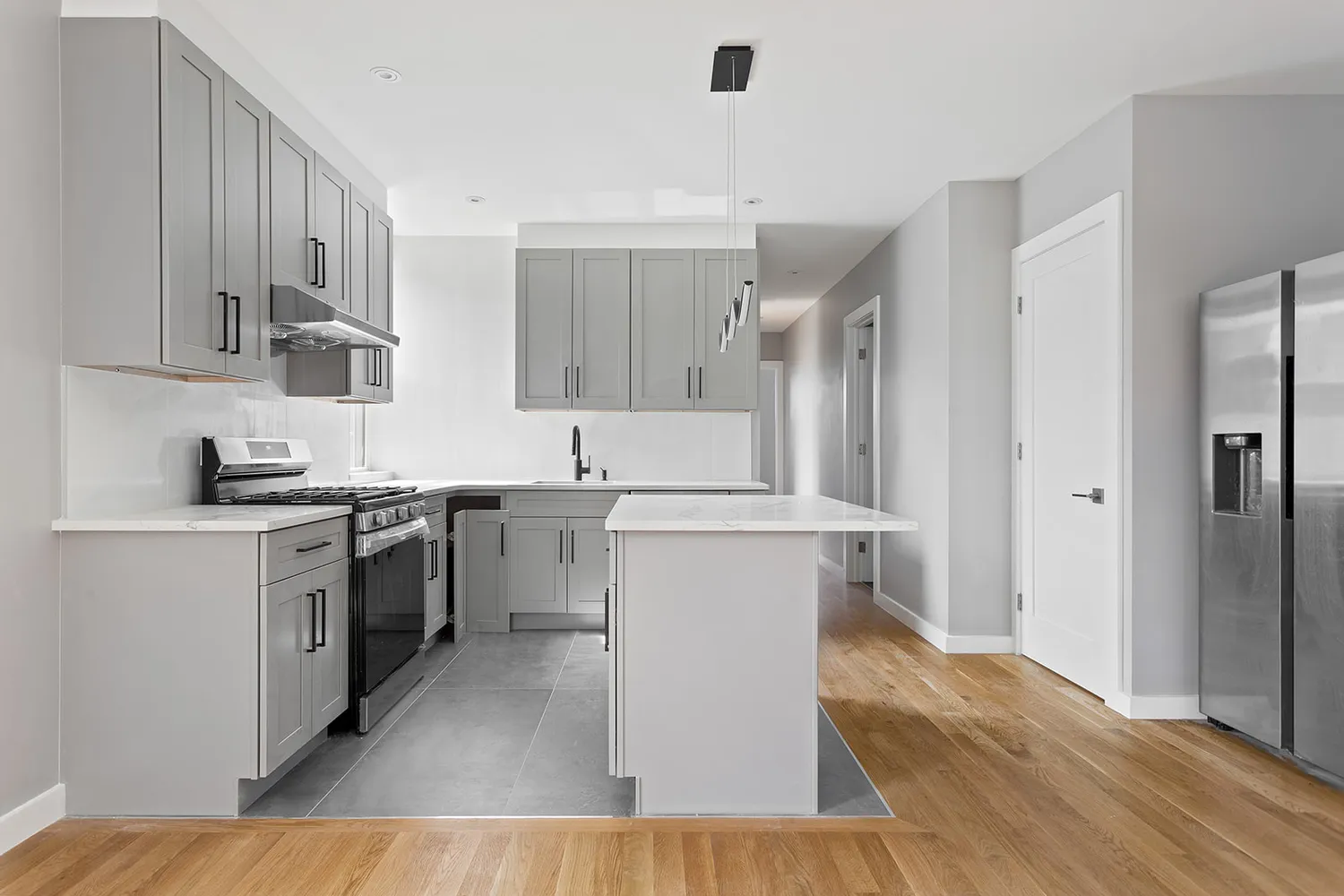 a kitchen with cabinets and wooden floor