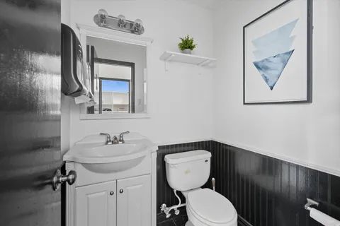 a bathroom with a toilet sink and mirror