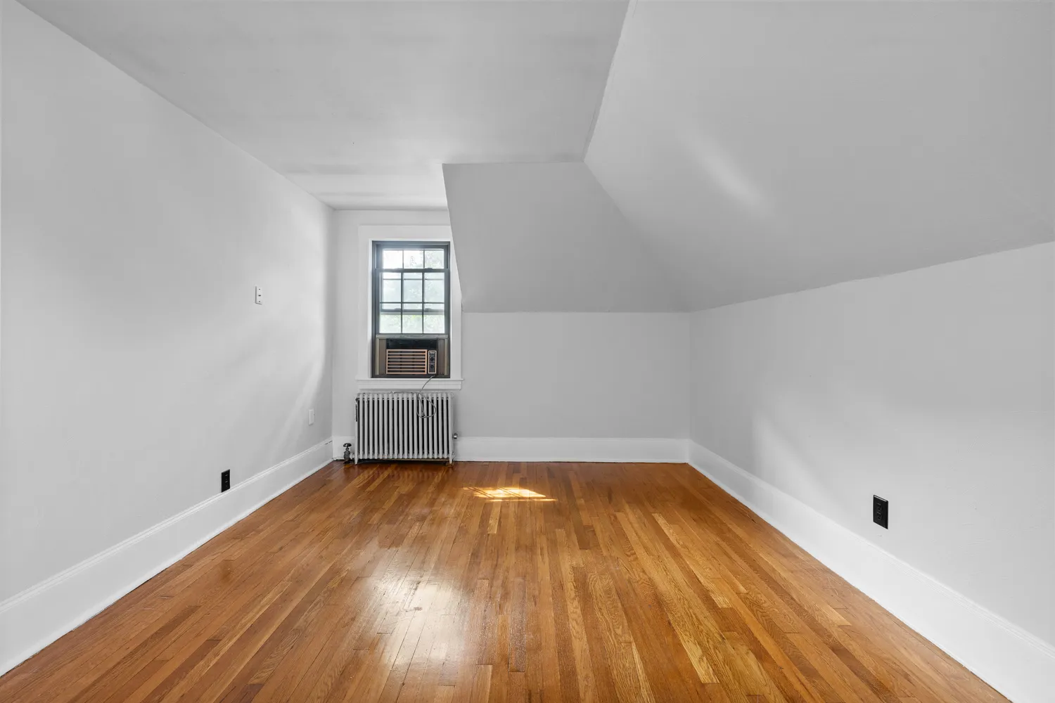 a view of a room with wooden floors and window