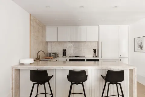 a kitchen with stainless steel appliances granite countertop a table chairs sink and cabinets