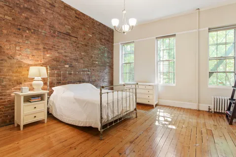 a spacious bedroom with a bed and a window