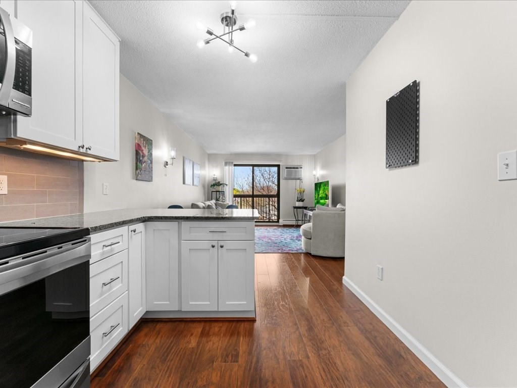 164 Galen Street, Unit 52 Watertown, MA 02472 - Photo 4 of 20 a kitchen with a refrigerator and a stove top oven