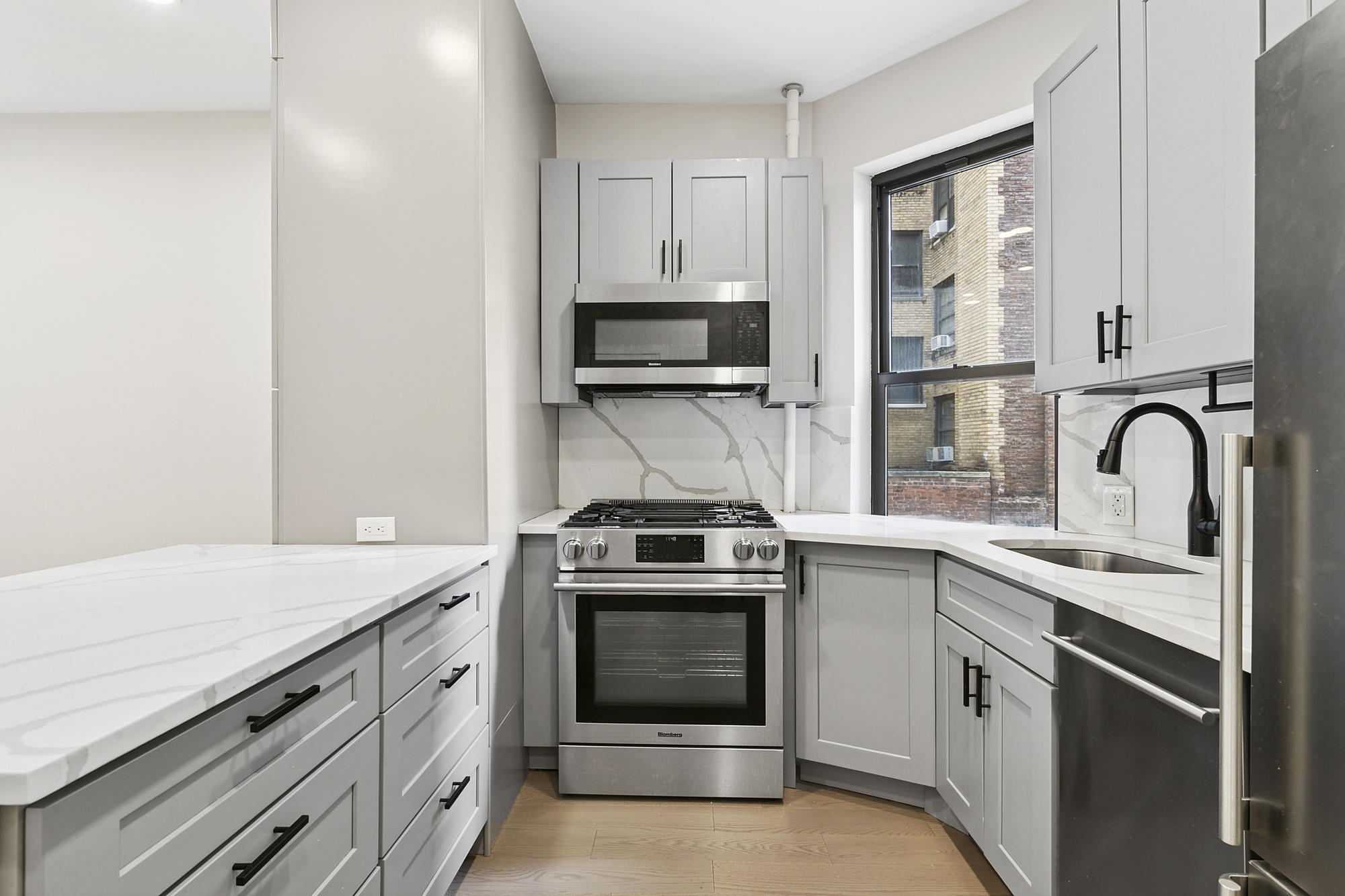 211 West 88th Street, Unit 2A Manhattan, NY 10024 - Photo 2 of 8 a kitchen with granite countertop a stove sink and refrigerator