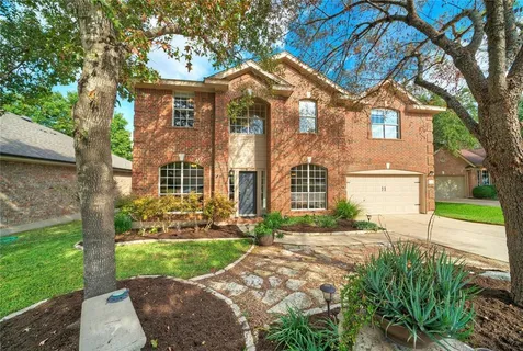 a front view of a house with a yard and potted plants