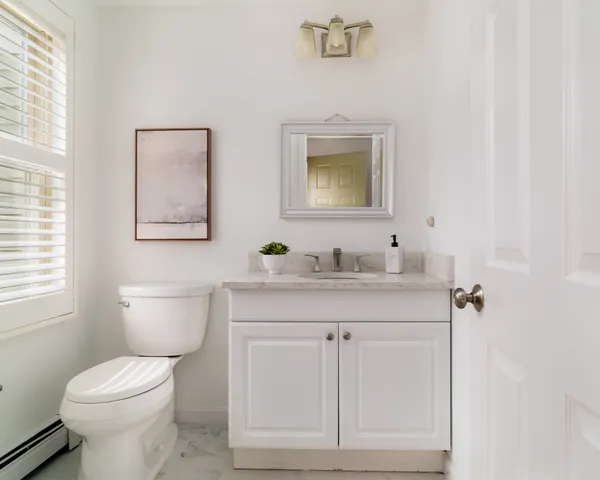 a bathroom with a toilet a sink and mirror