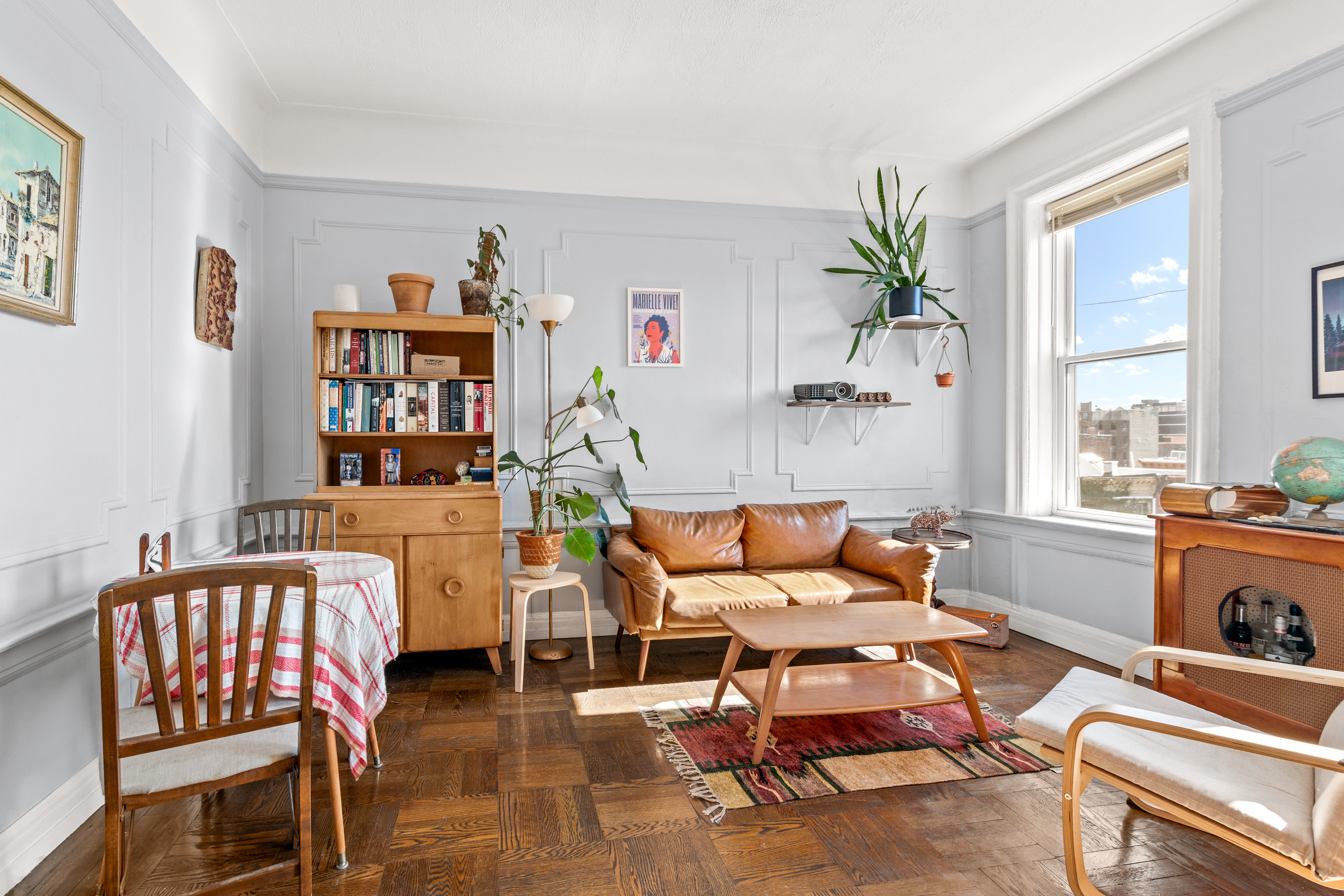 a living room with furniture a bookshelf and a window