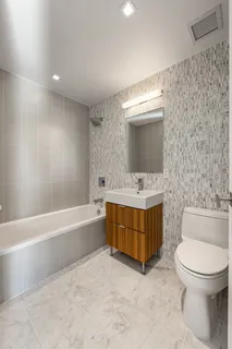 a bathroom with a tub sink toilet and mirror