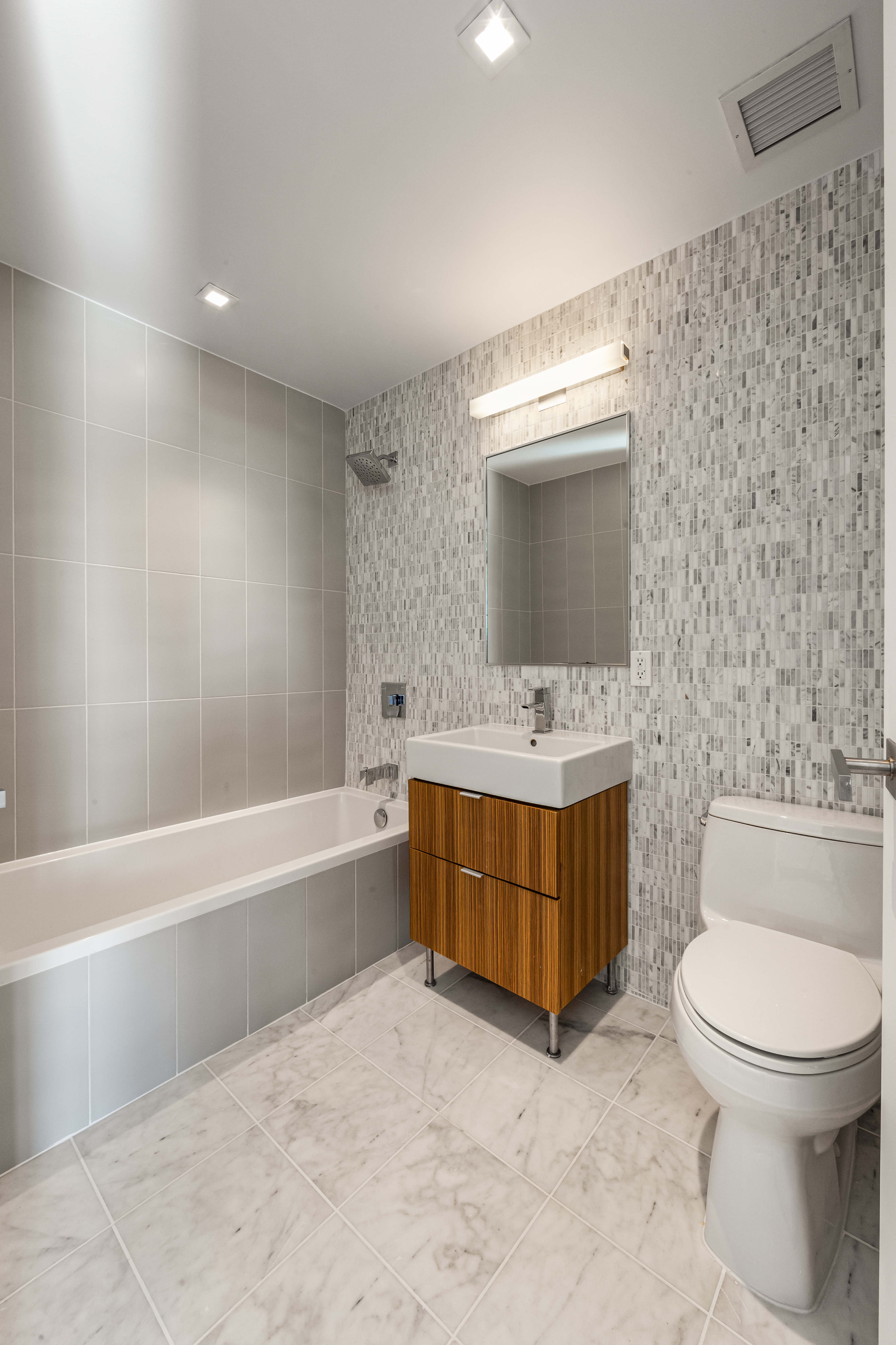 202 8th Street, Unit 4A Brooklyn, NY 11215 - Photo 5 of 16 a bathroom with a tub sink toilet and mirror