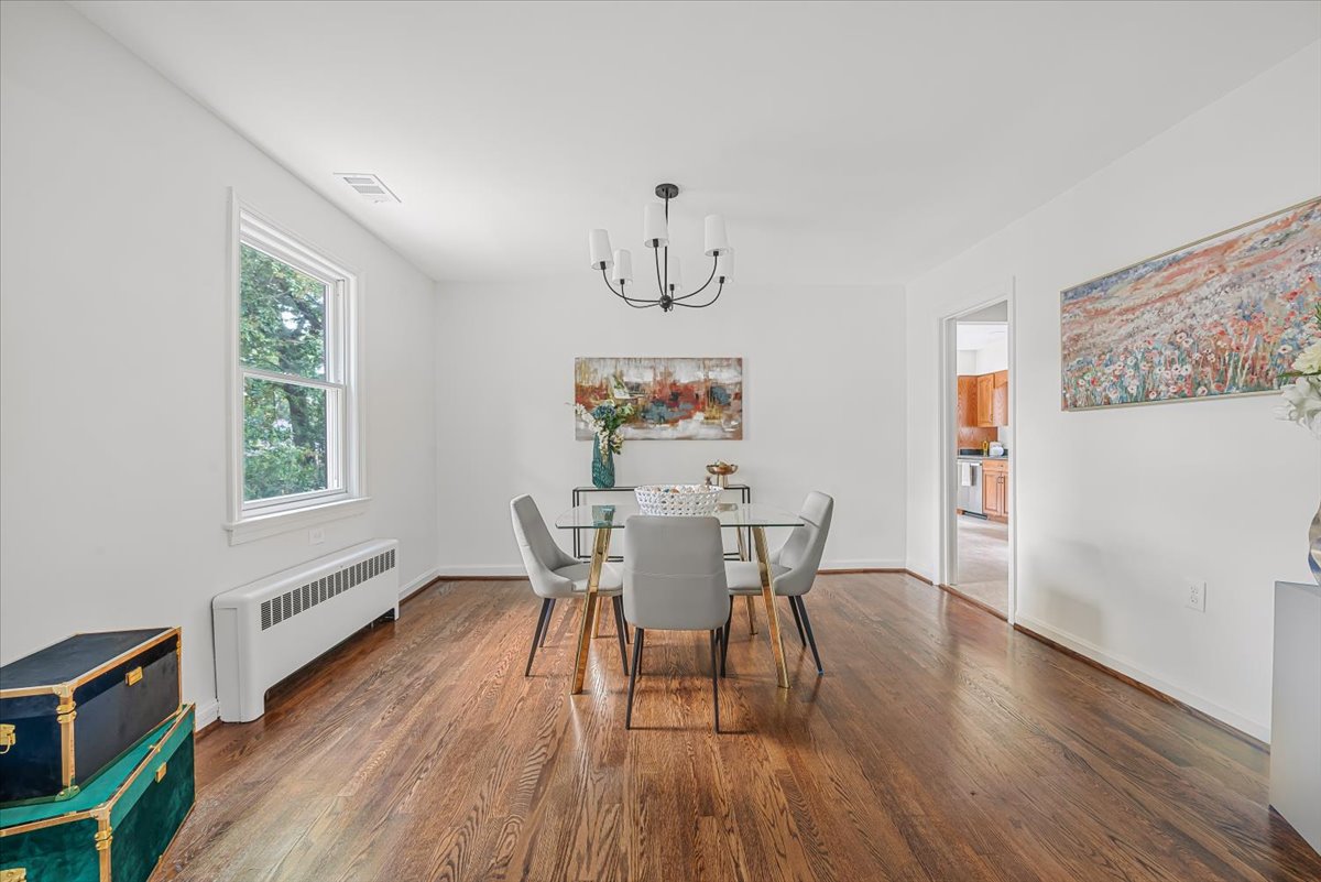 1902 Rookwood Road Silver Spring, MD 20910 - Photo 9 of 36 a dining room with wooden floor a chandelier a wooden table and chairs