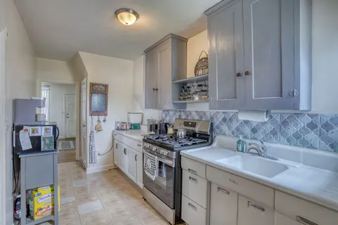 a kitchen with stainless steel appliances a sink stove and cabinets