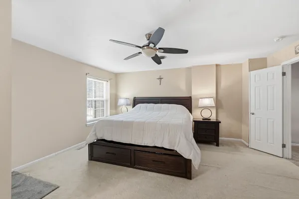 a spacious bedroom with a bed and a ceiling fan