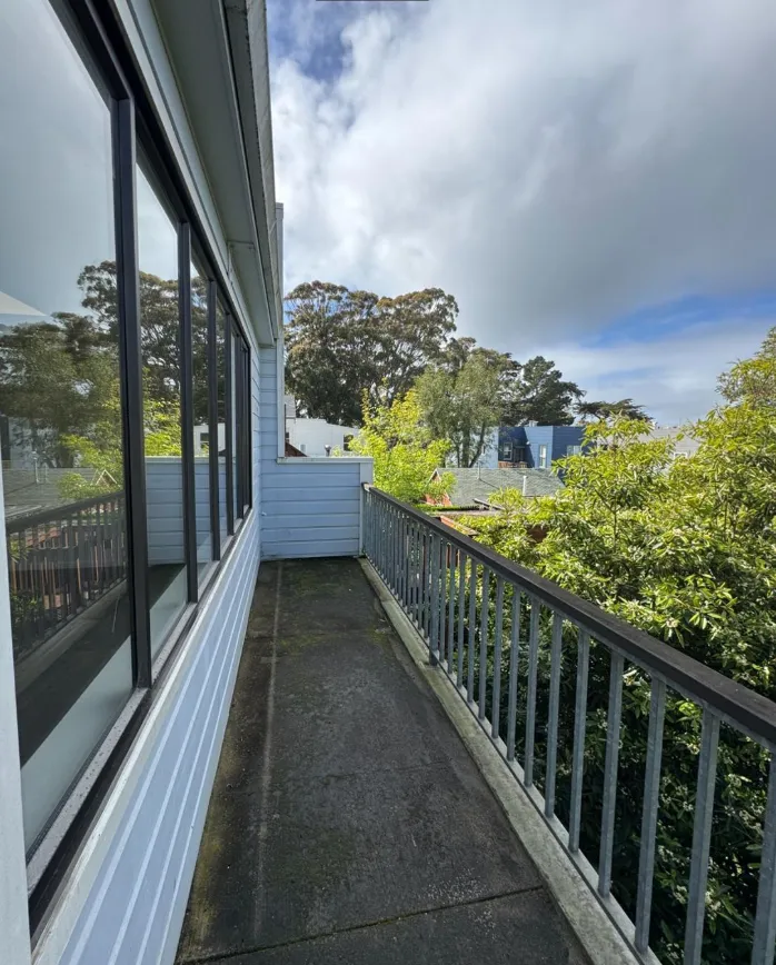 a view of a house with a street from a balcony