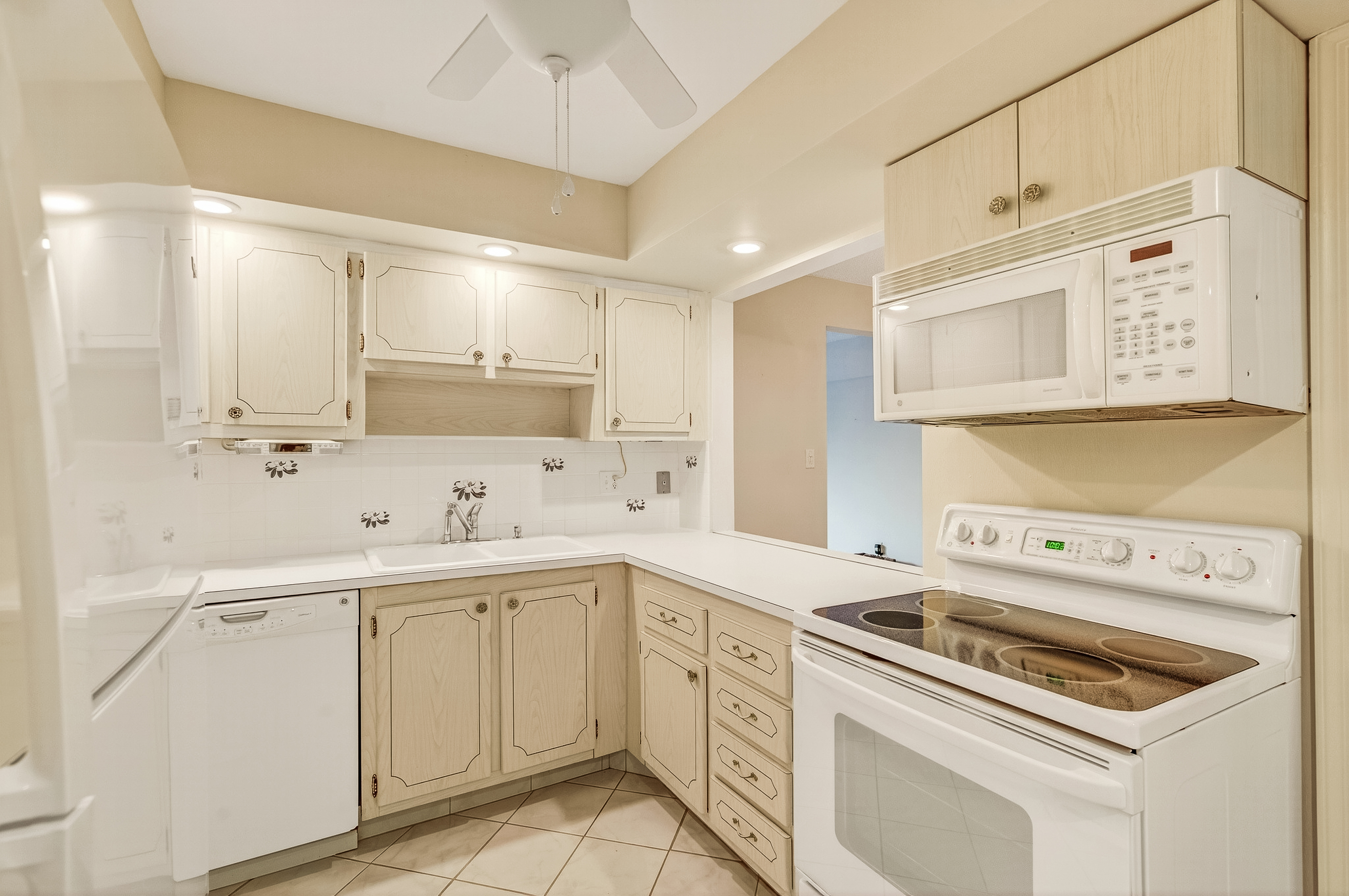 4601 Highway A1a, Unit 102 Vero Beach, FL 32963 - Photo 4 of 29 a kitchen with cabinets appliances a sink and a counter top space