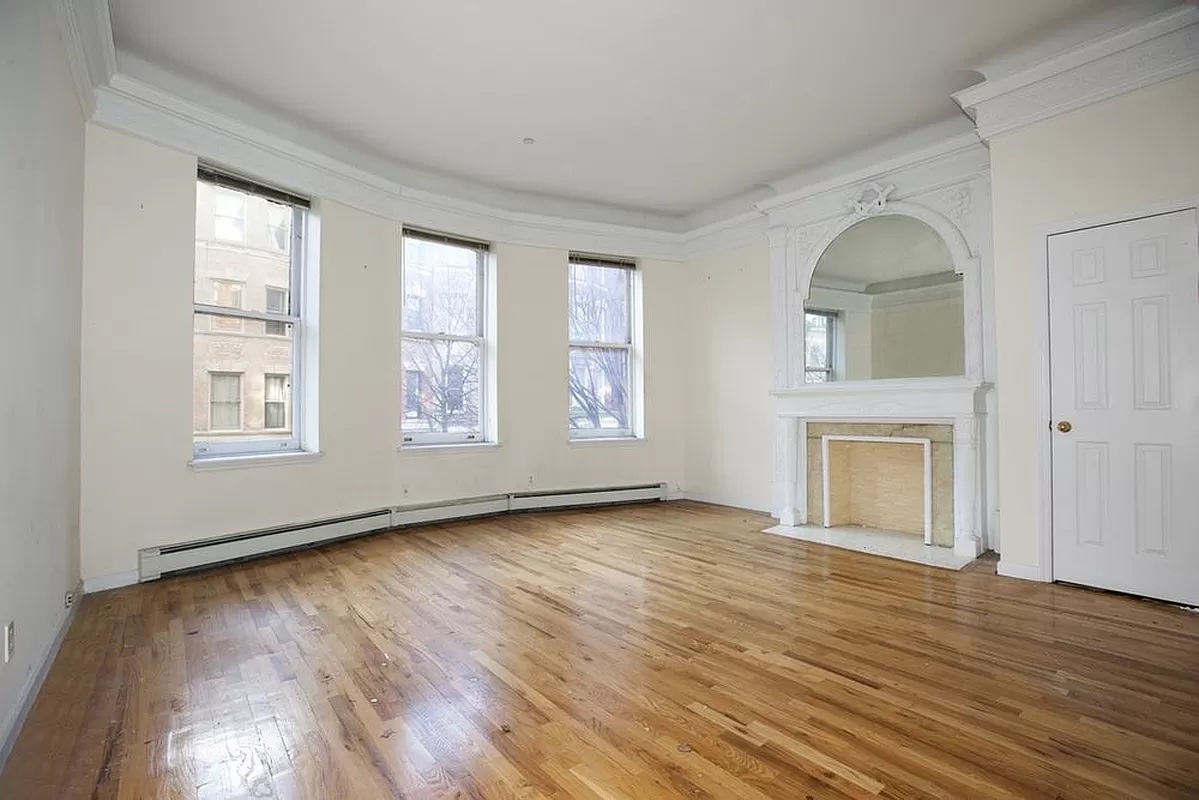 469 West 141st Street Manhattan, NY 10031 - Photo 3 of 14 a view of an empty room with window and wooden floor