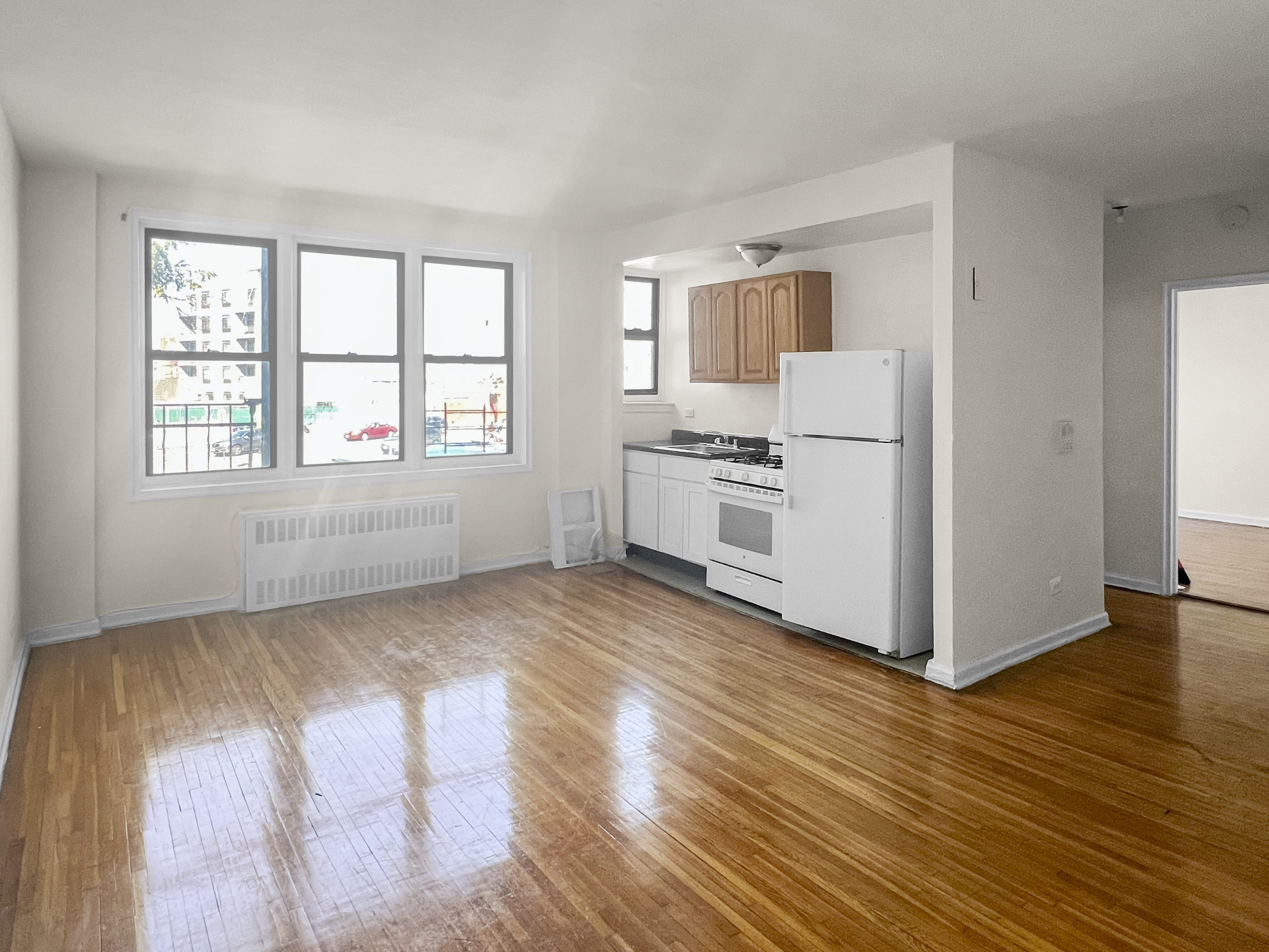 a view of a kitchen with wooden floor and electronic appliances