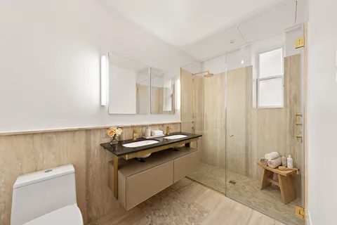 a bathroom with a granite countertop sink a toilet and a mirror