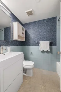 a bathroom with a toilet sink and mirror