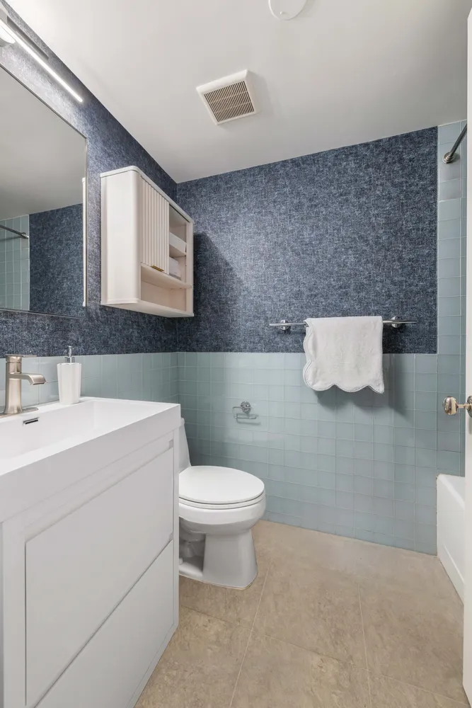 a bathroom with a toilet sink and mirror